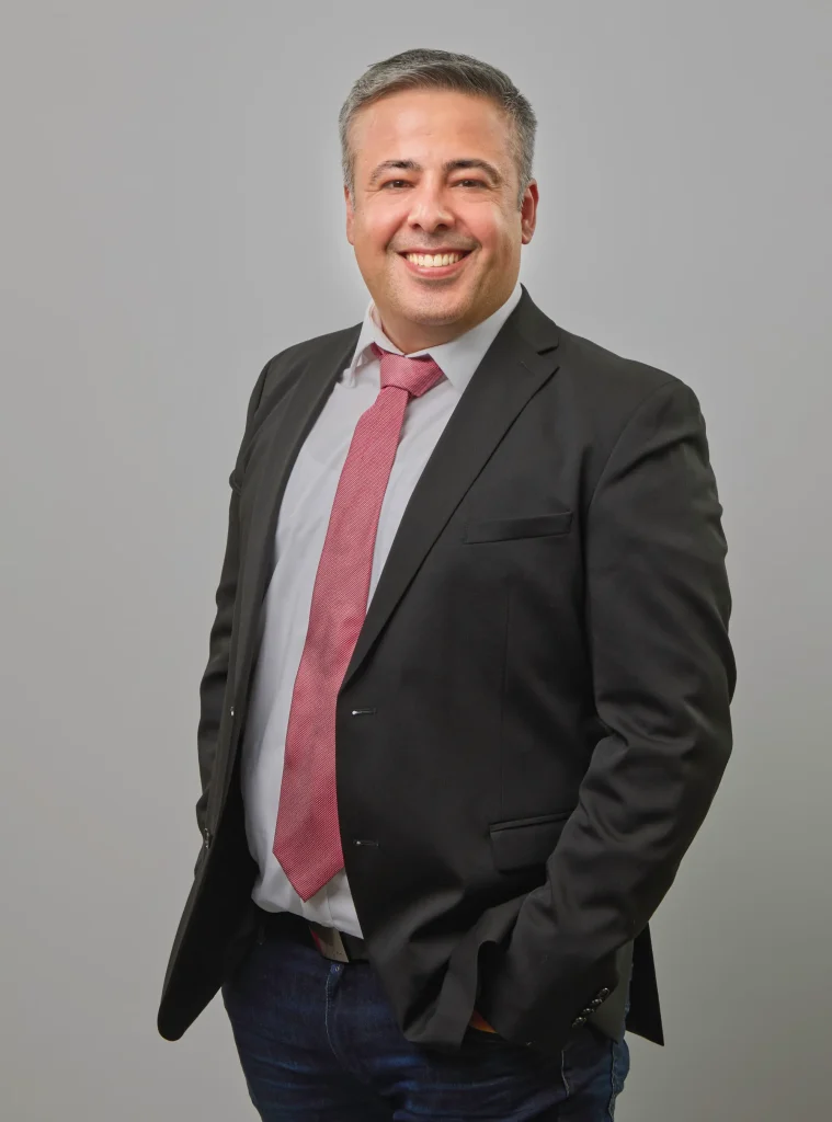 Kassra Adloo im Business Look mit Anzug und roter Krawatte